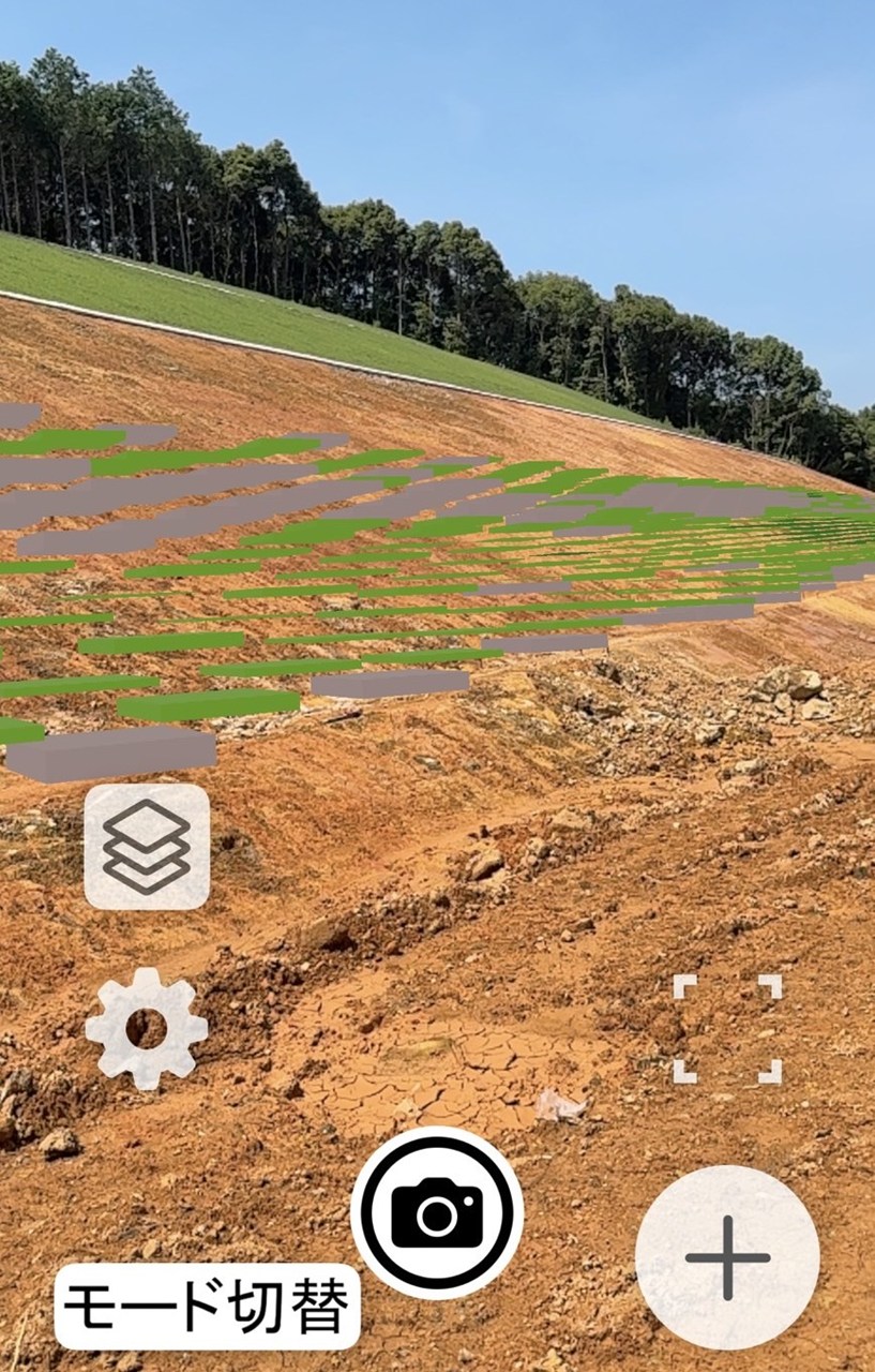 施工現場の映像に、設計との差を色分けしたヒートマップをAR表示するiPhone画面